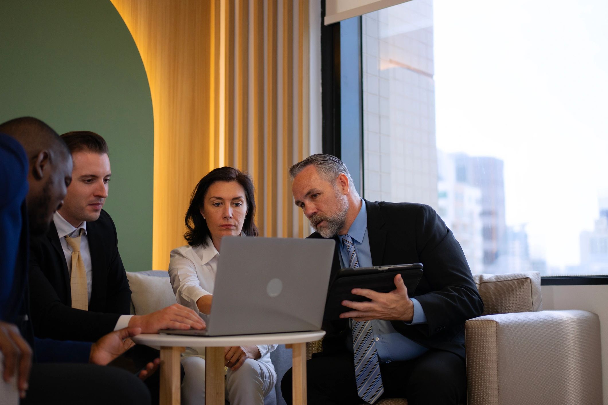Office team collaborating around laptops for project planning